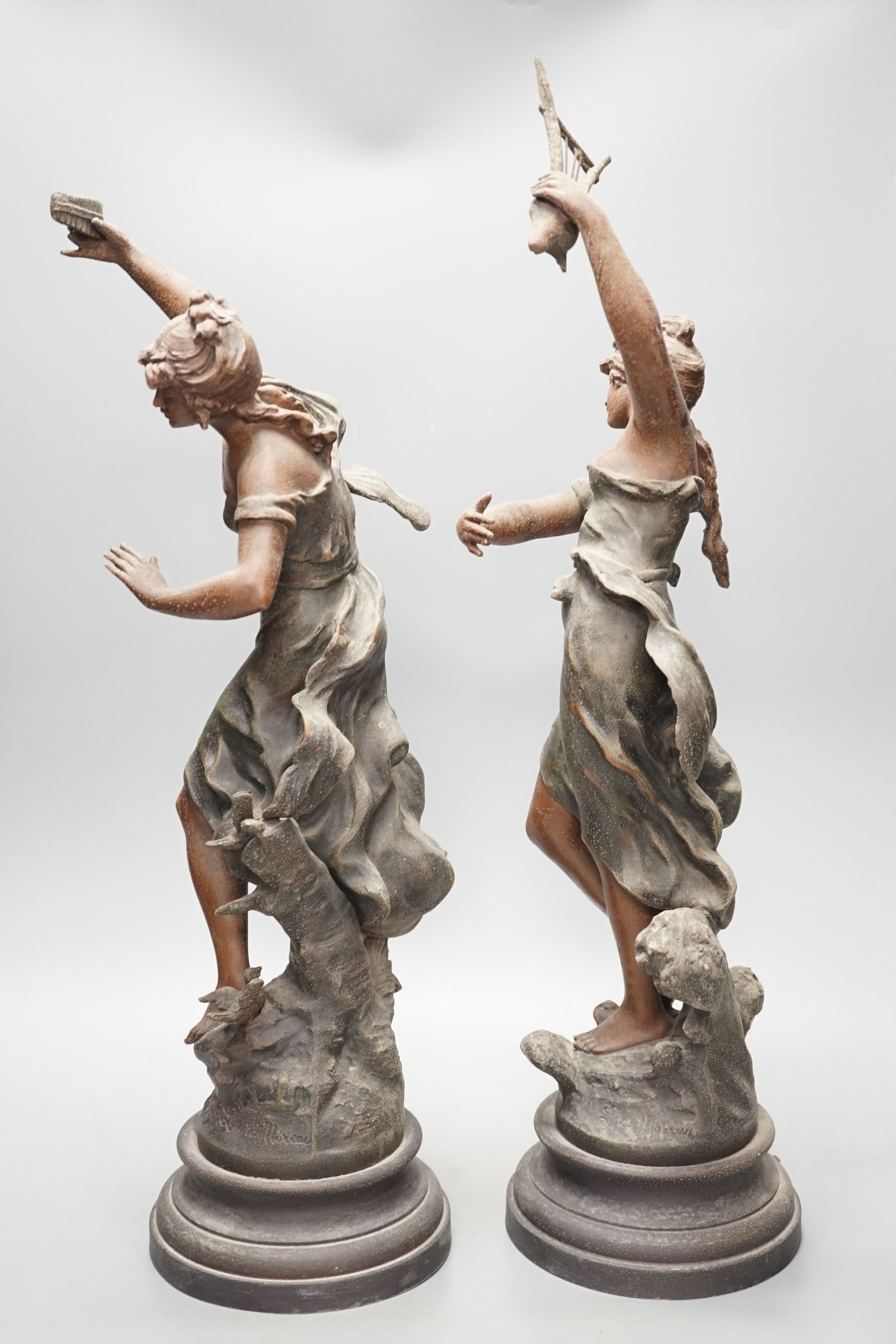 A pair of patinated spelter figures of musical maidens, tallest 58 cms high.